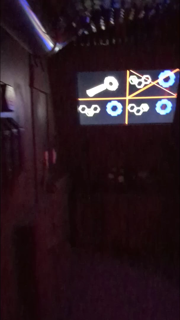 Alien symbols displayed above the controls in the red-lit bay.