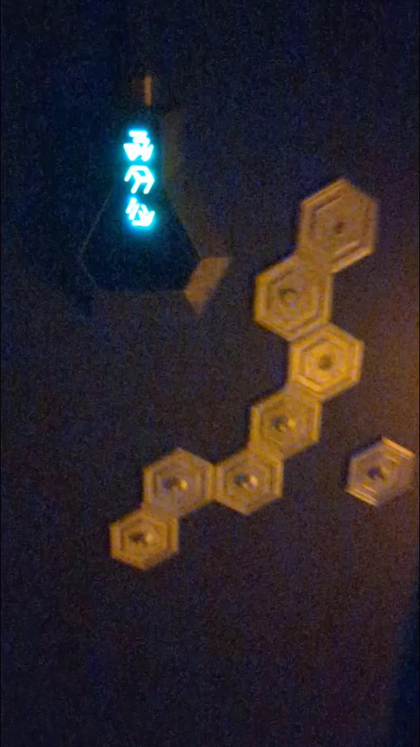 Hexagonal glyph pieces beside illuminated alien symbols.